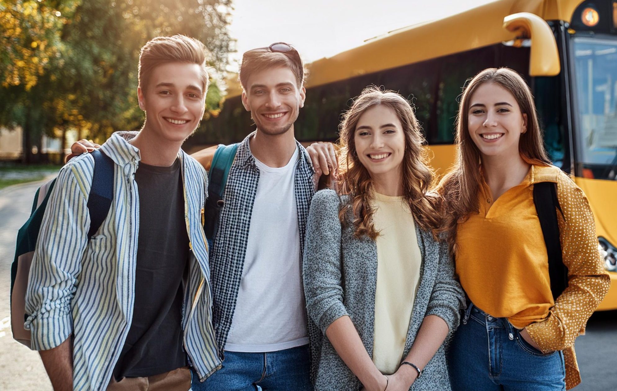 a group of students posing infront of a bus